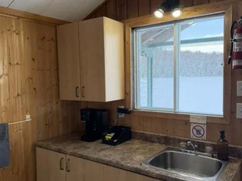 Functional kitchen corner with sink, coffee maker, and exterior view in cottage 5.