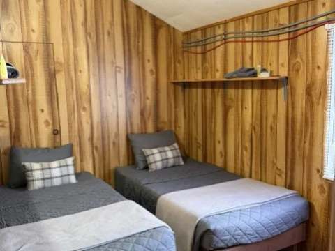 This bedroom in cabin 5 includes two single beds with full bedding.