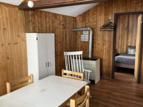 The dining area of cabin 6 with its wooden table and chairs.