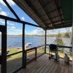 View of the lake and dock from the cottage's screened-in porch equipped with a barbecue.