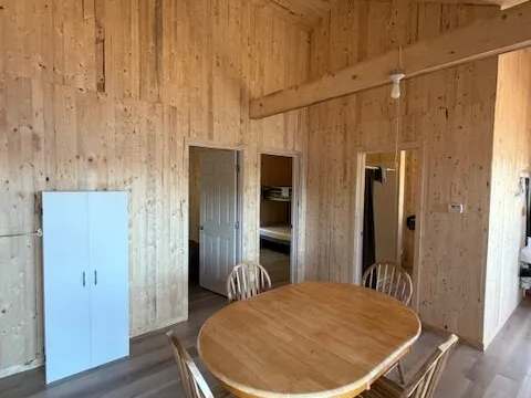 The dining area of chalet 8 featuring natural wood paneling.