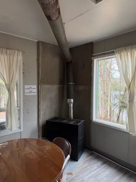 A wood stove and dining table in the cabin's living area.