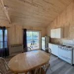 View of the cottage kitchen and dining area with its natural wood walls.