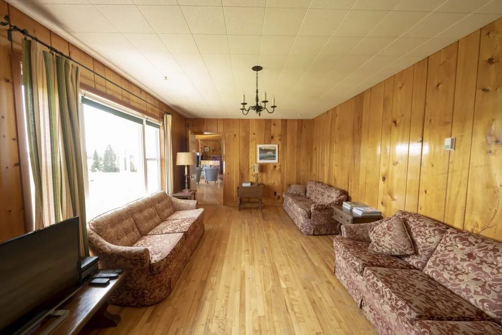 The inn's living room features wood-paneled walls and several comfortable sofas.