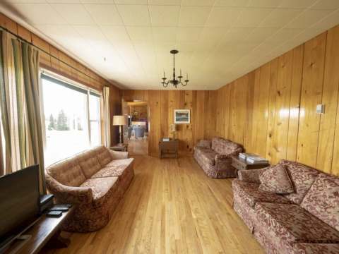 The inn's living room features wood-paneled walls and several comfortable sofas.