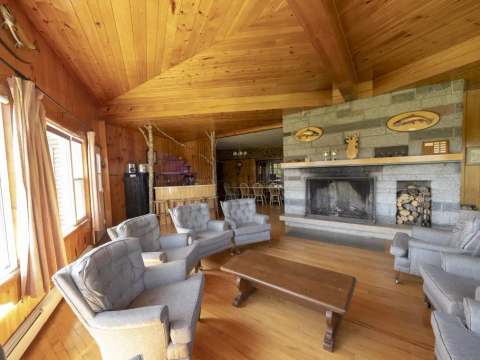 The inn's living area features a stone fireplace and comfortable armchairs.