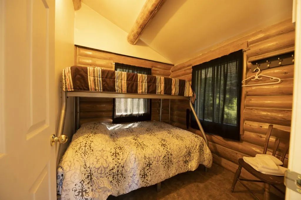 This rustic bedroom is equipped with a bunk bed featuring a double bed on the bottom.