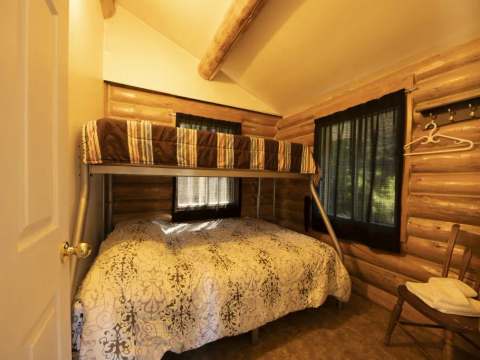 This rustic bedroom is equipped with a bunk bed featuring a double bed on the bottom.