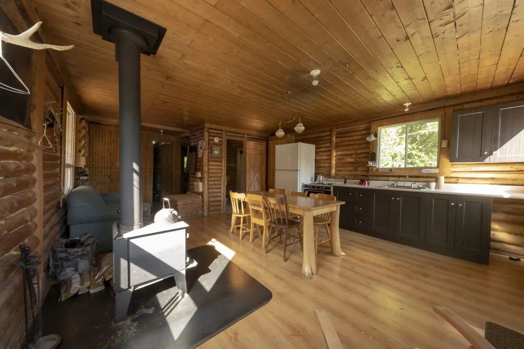 The open area includes a kitchen, a dining table, and a wood stove.