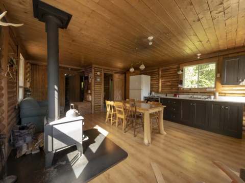 The open area includes a kitchen, a dining table, and a wood stove.