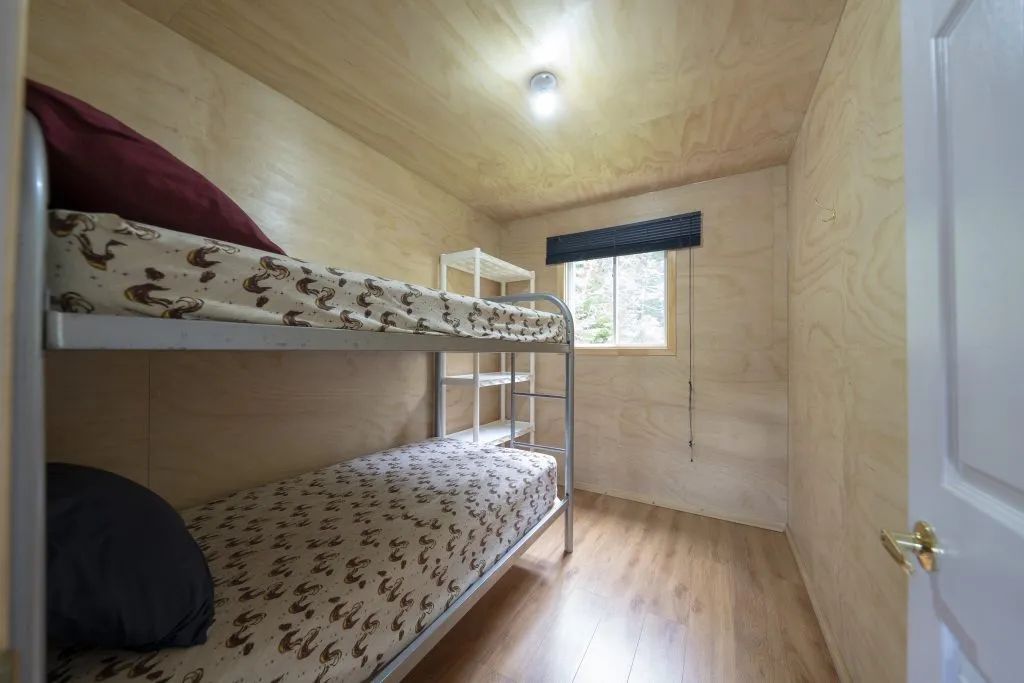This bedroom features a bunk bed with a natural wood finish.