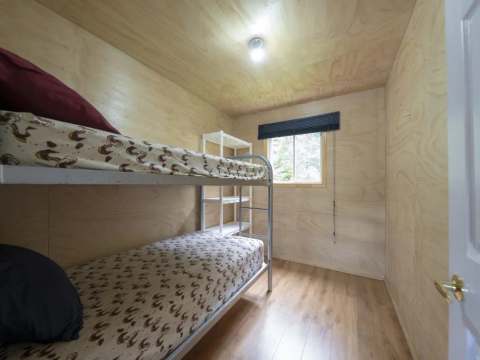 This bedroom features a bunk bed with a natural wood finish.