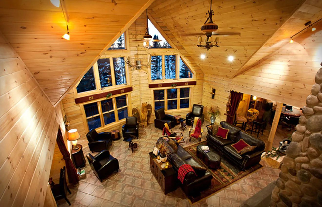 The lodge's spacious living room offers a warm atmosphere with its large windows and fireplace.