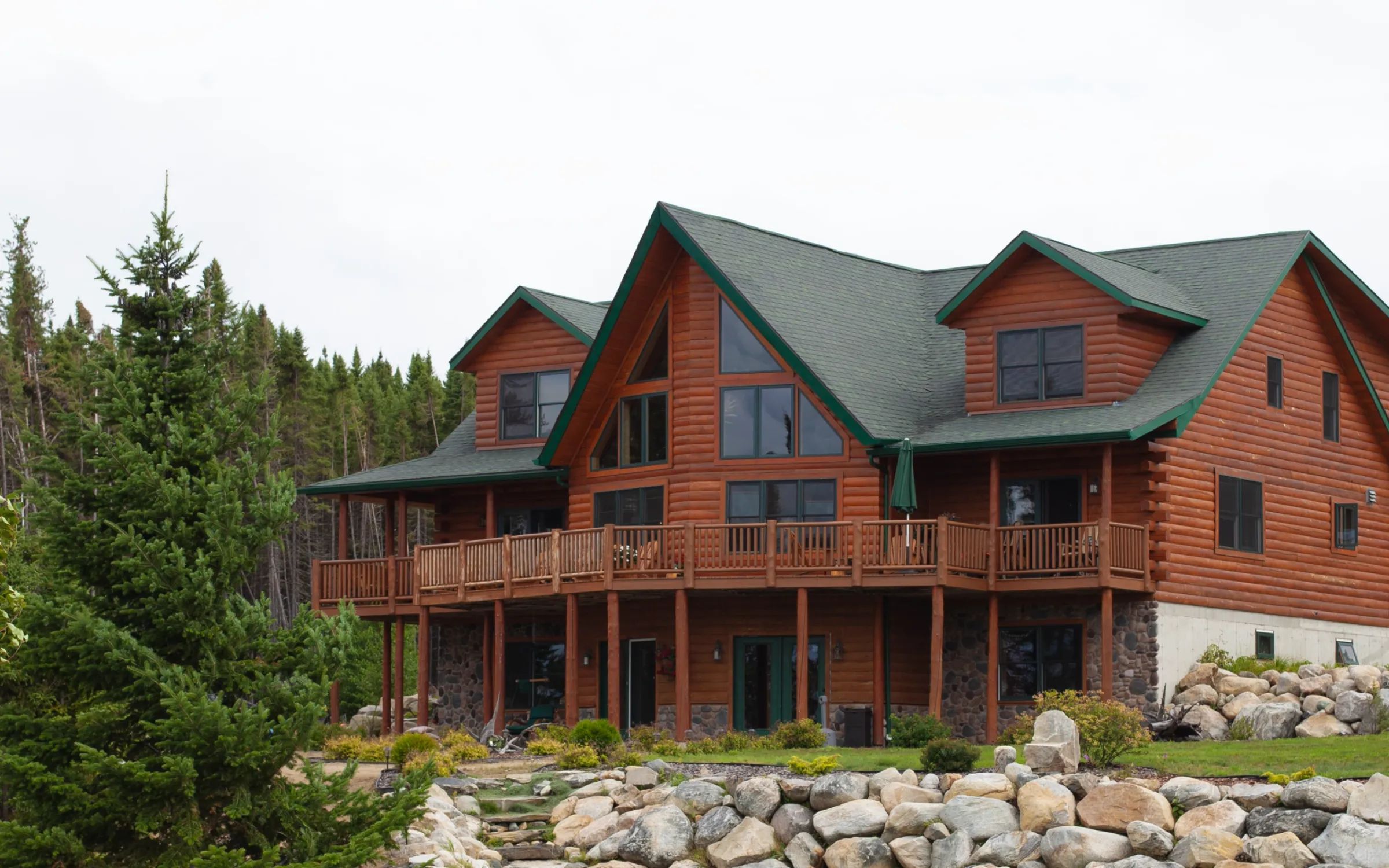 The St-Cyr Royal lodge features a log structure with a large outdoor deck.