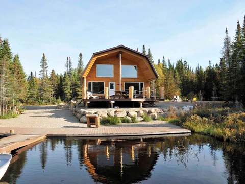 Le chalet Petit bois franc avec sa grande terrasse au bord de l'eau.