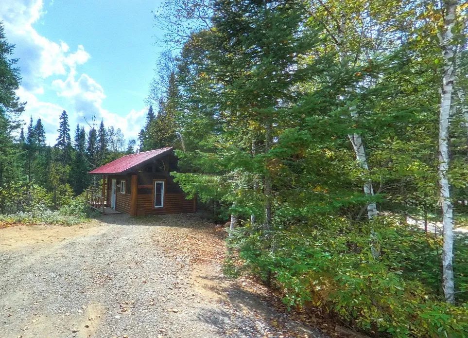 Le mini chalet Le St-Régis est situé en forêt près d'un chemin boisé.