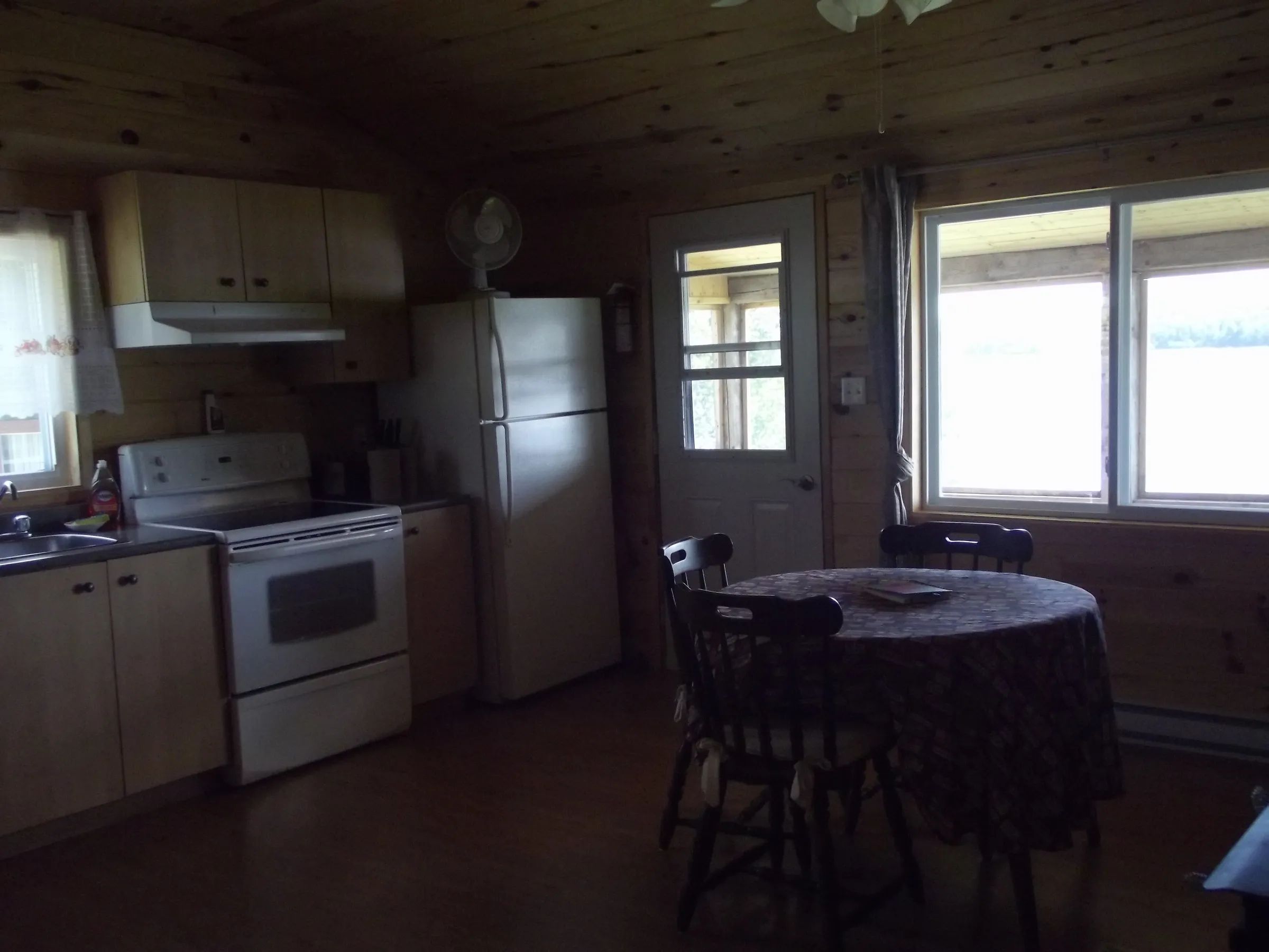 The cabin's equipped kitchen features a dining table and a view of the outdoors.