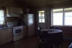 The chalet's equipped kitchen features a dining table and an exterior view.