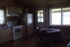 The chalet's equipped kitchen features a dining table and an exterior view.