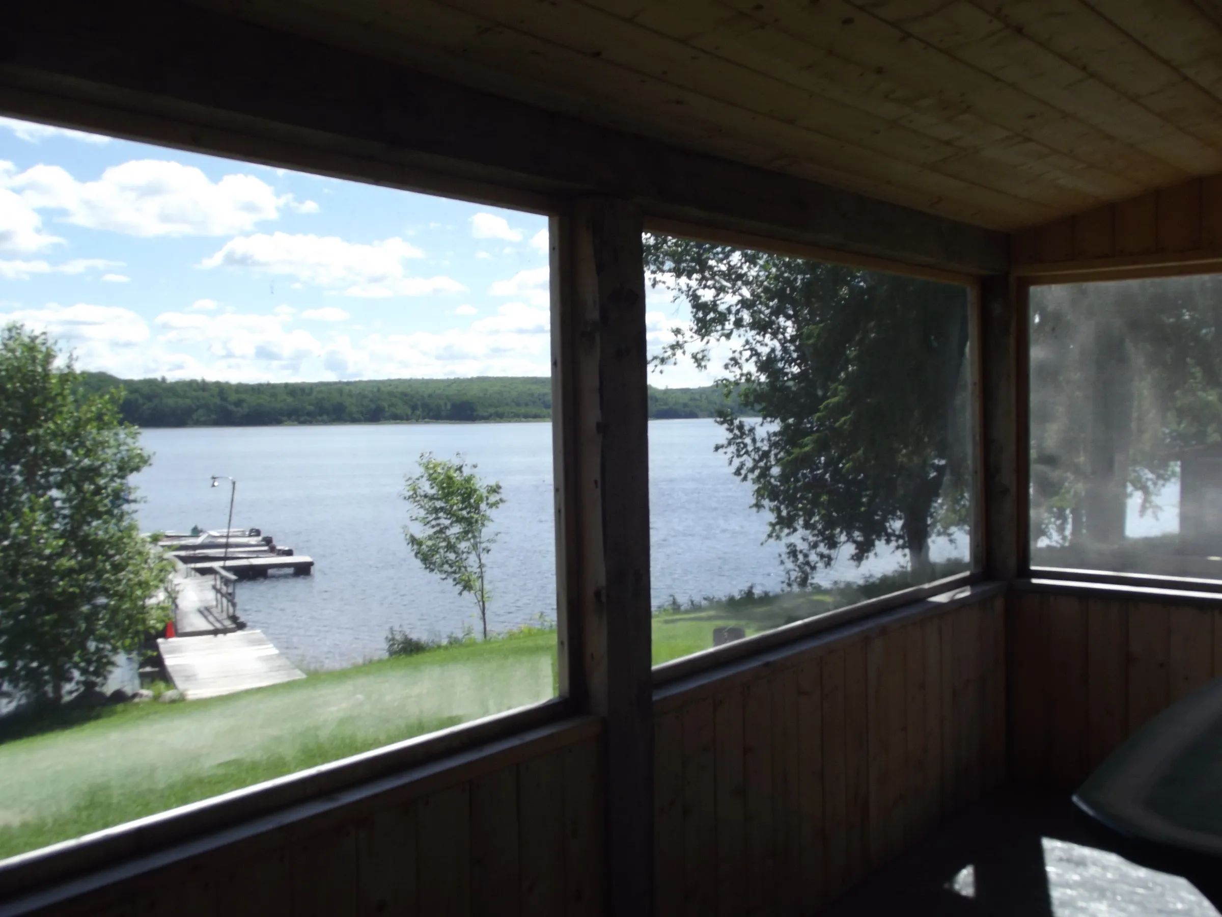 Panoramic view of the lake and dock from the chalet's screened porch.