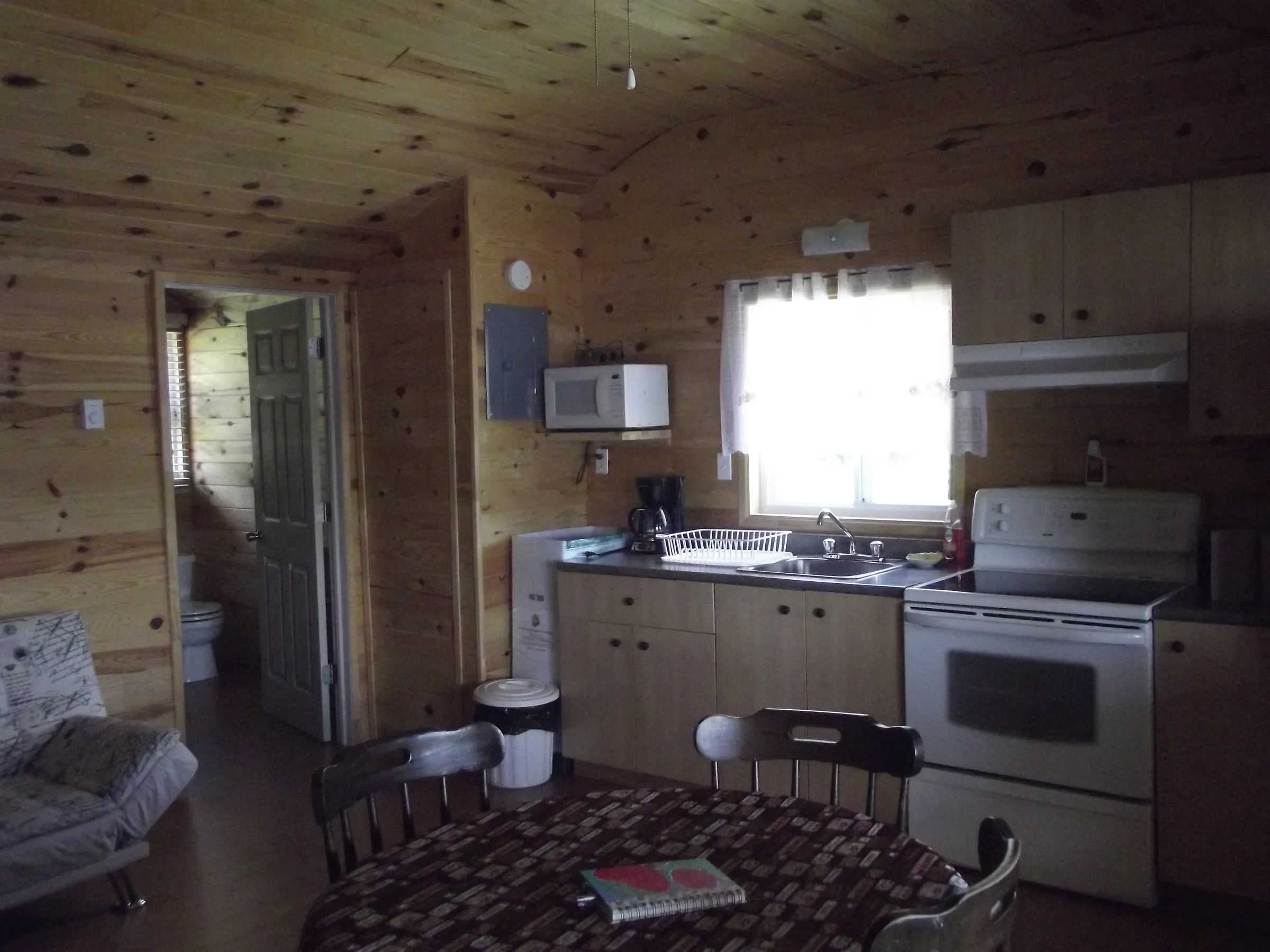The equipped kitchen and dining area of cottage 1 offer a warm, all-wood space.