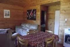 The dining area and living room of chalet 10 feature a warm wooden interior.