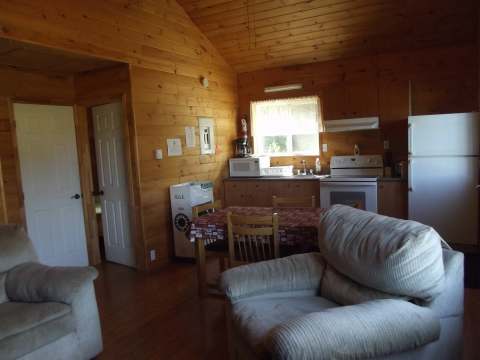 The open-plan cottage area includes an equipped kitchen, a dining area and a comfortable living room.