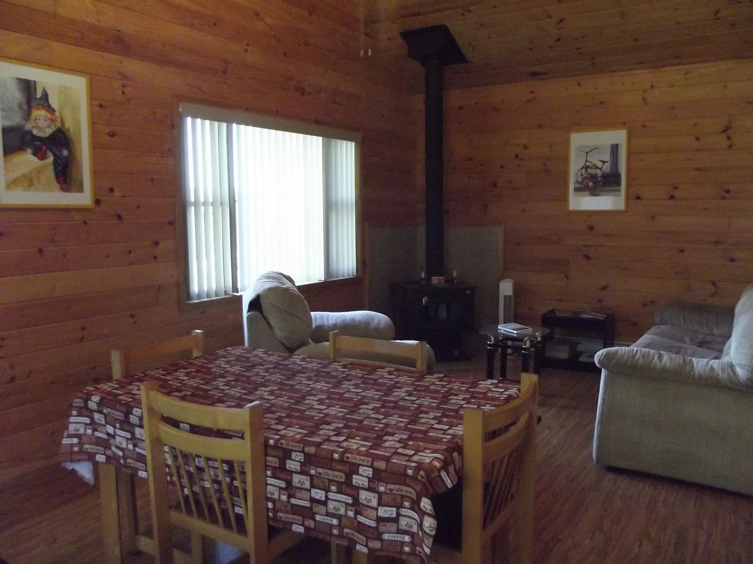 The cottage's dining and living area features a wood stove and comfortable furniture.