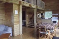 The open area of the cabin includes an equipped kitchen, a dining table and a living room.