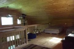 The loft of chalet 11 features two beds and an overlooking view of the ground floor.