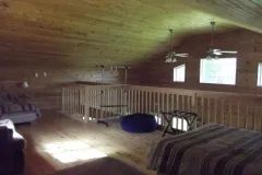 View of the spacious, wood-paneled chalet mezzanine featuring comfortable beds.