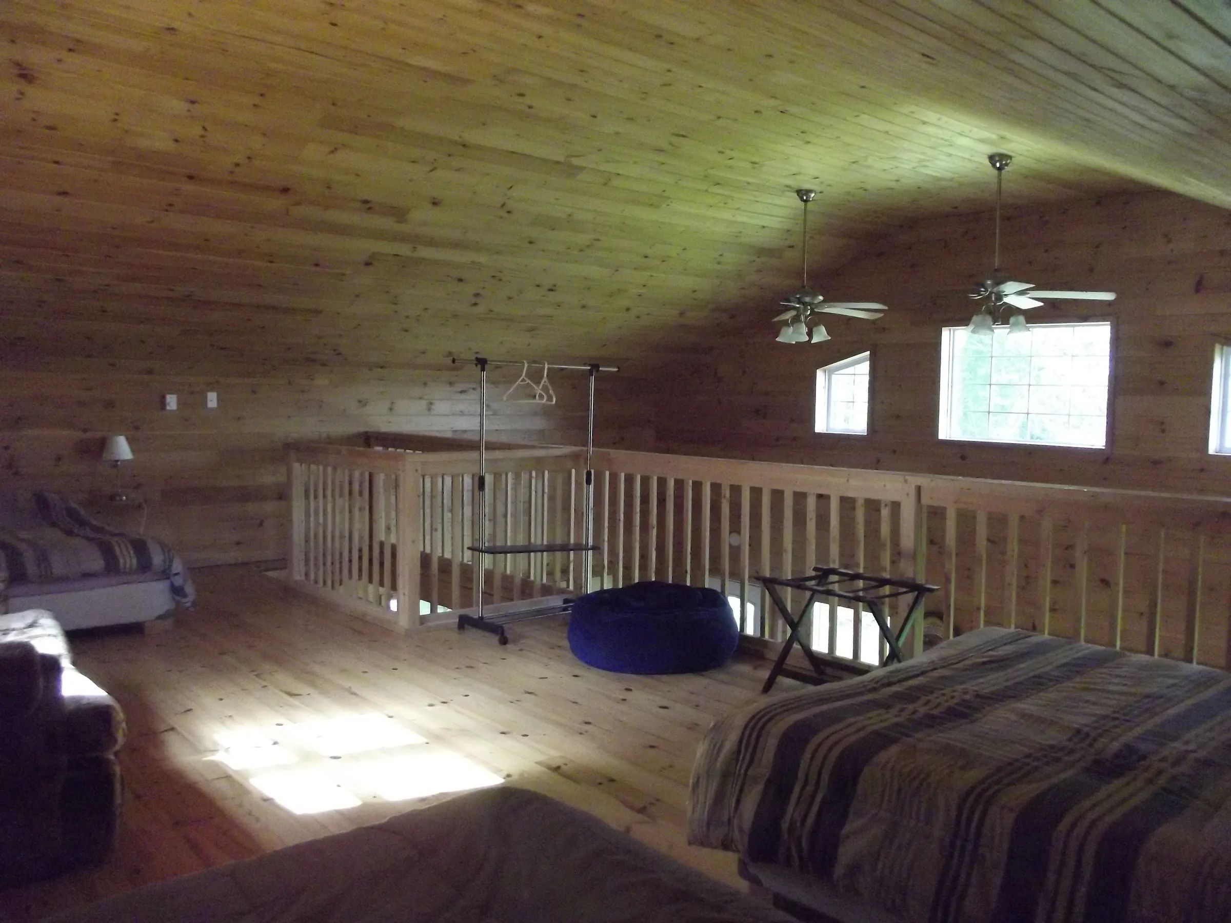 The chalet's loft area provides sleeping spaces with warm wood finishing.