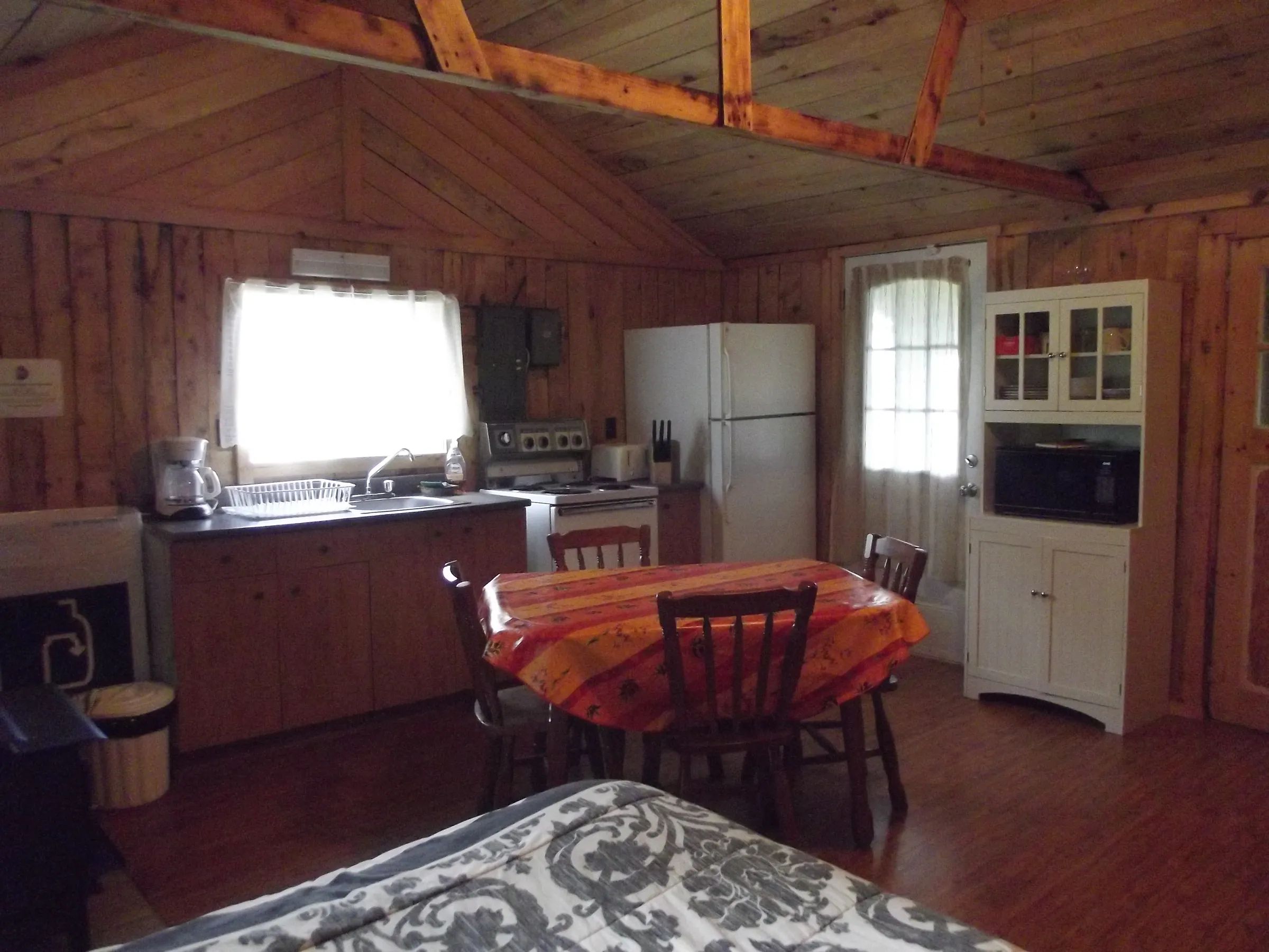 L'aire de vie principale du chalet comprend une table à manger, un coin salon et un espace cuisine.