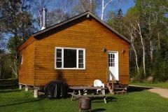 Vue extérieure du chalet 10, incluant une table à pique-nique et un barbecue à l'extérieur.