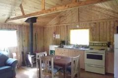 Le chalet 5 comprend une cuisine fonctionnelle et un coin repas avec un poêle à bois.
