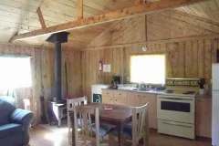 Le chalet 5 comprend une cuisine fonctionnelle et un coin repas avec un poêle à bois.