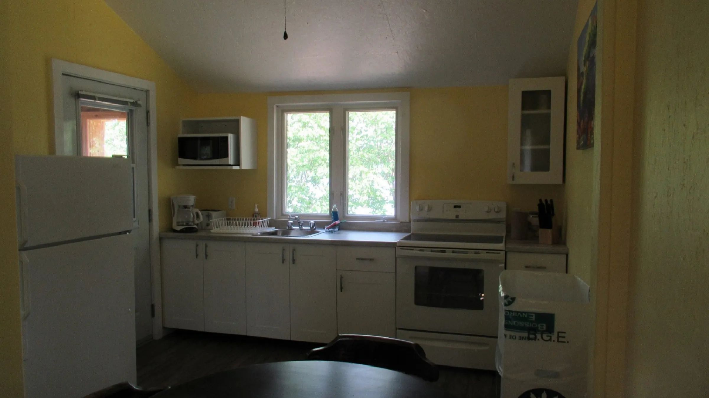 The cottage's functional kitchen includes a stove, a refrigerator, and a workspace.