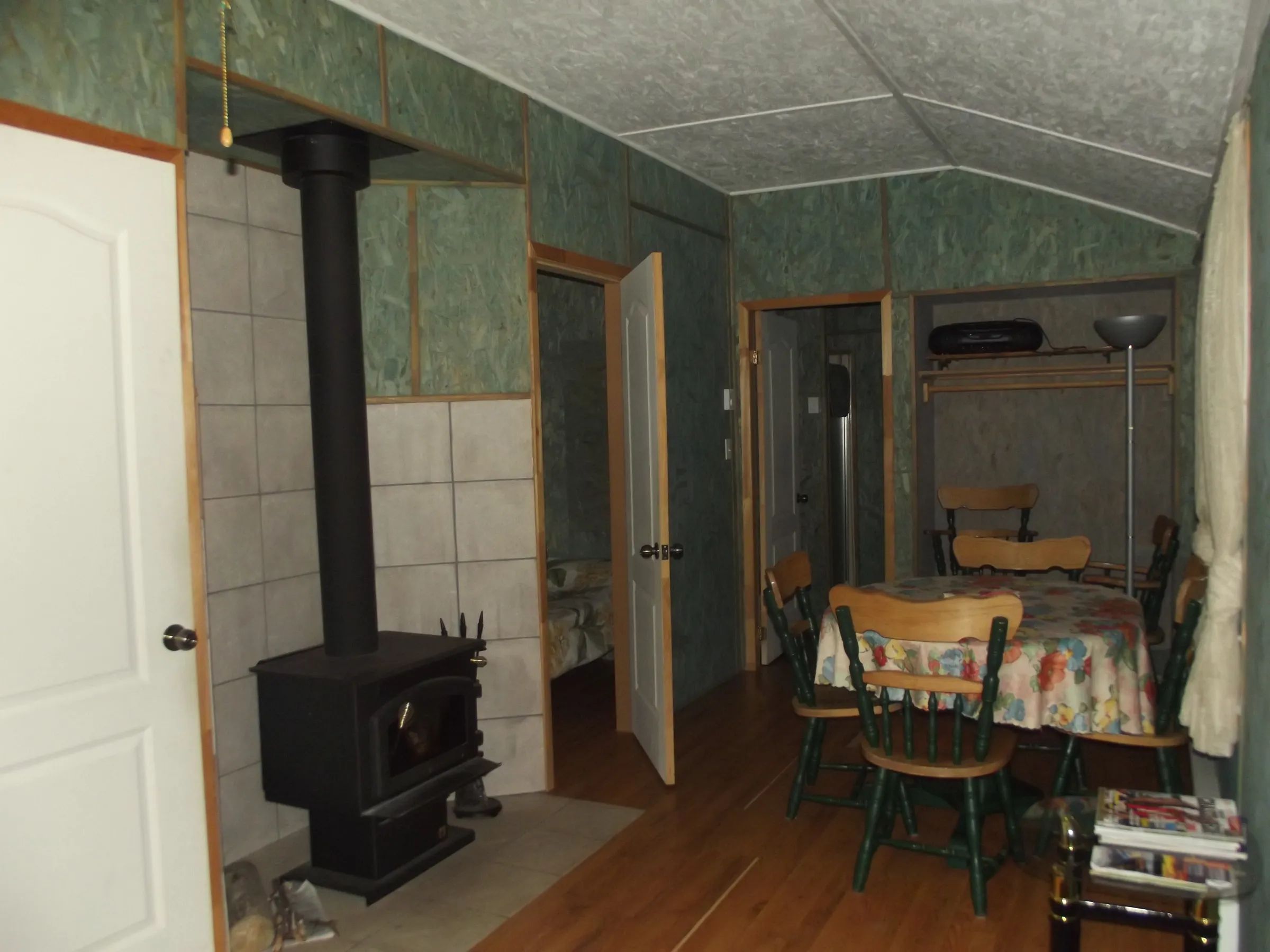 Interior view of cottage 7 featuring its wood stove and dining area.