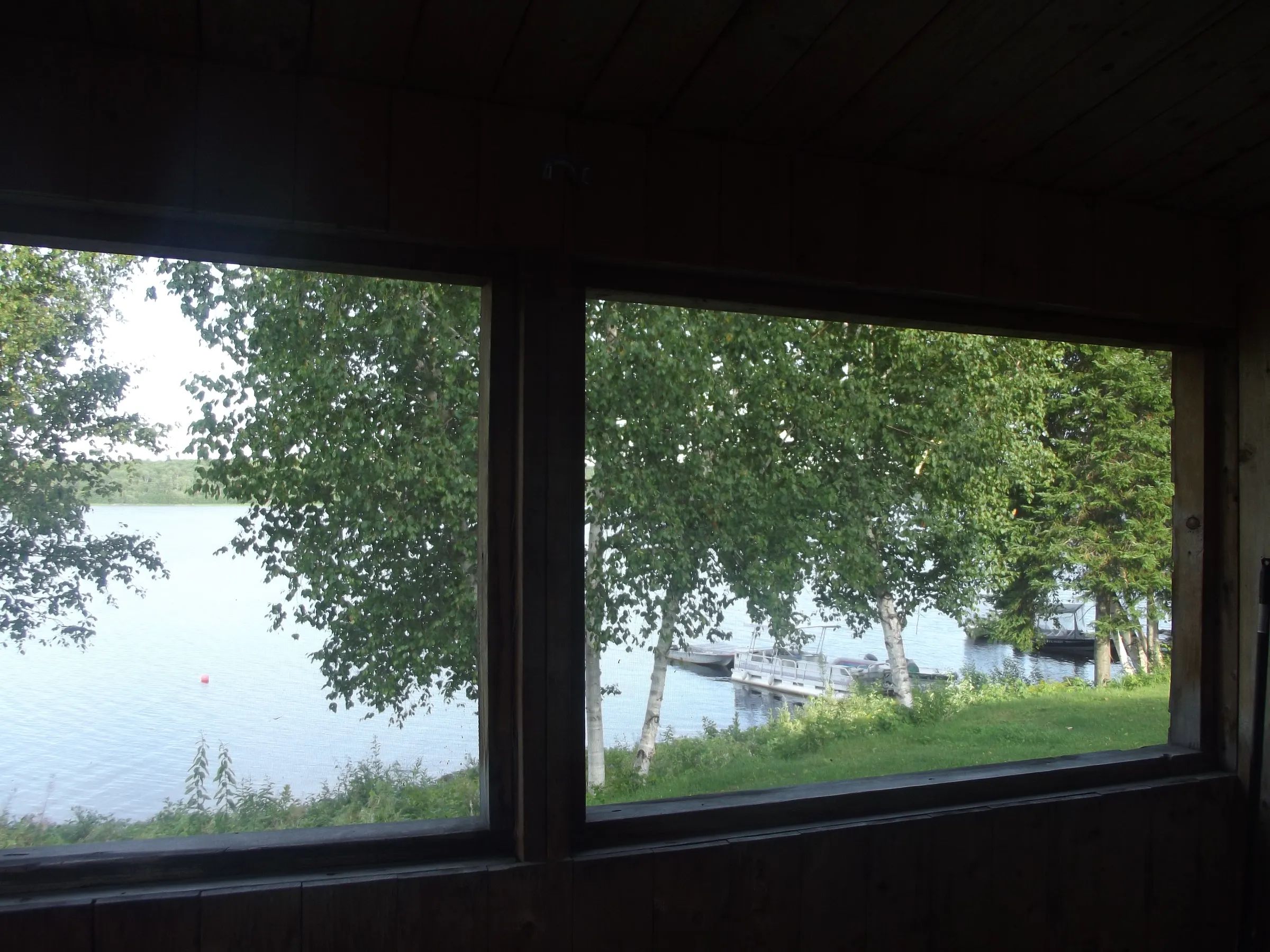 View of the lake and the dock from inside the cabin.