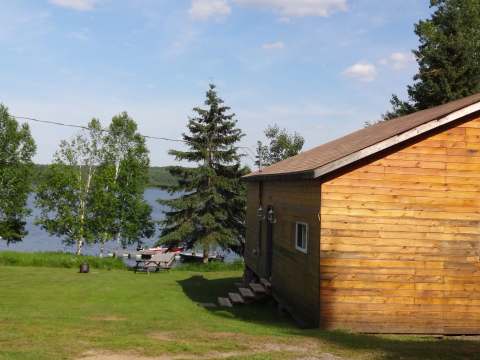 Vue latérale du chalet 9, situé à proximité du lac avec une aire de repos extérieure.