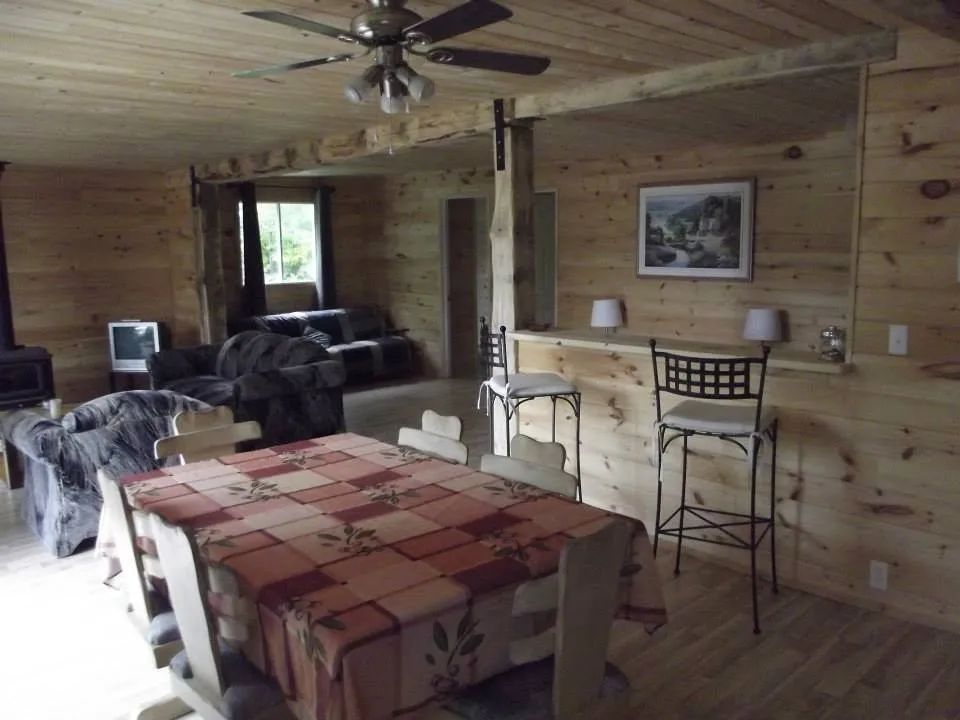 Vue d'ensemble de l'aire ouverte comprenant la salle à manger et le salon du chalet 9.