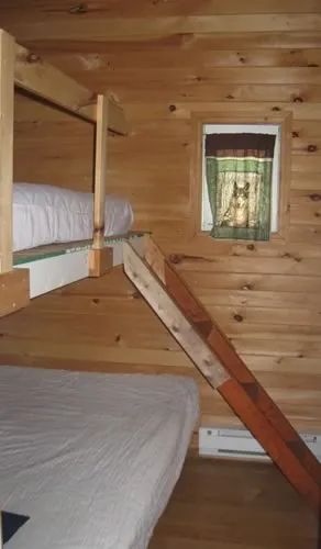 Chalet 3 is equipped with wooden bunk beds with bedding.