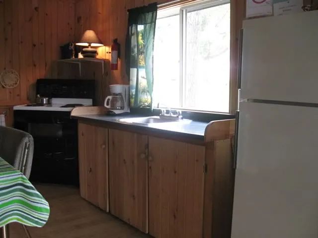 The equipped kitchen of cottage 3 includes a stove, a refrigerator, and a sink.