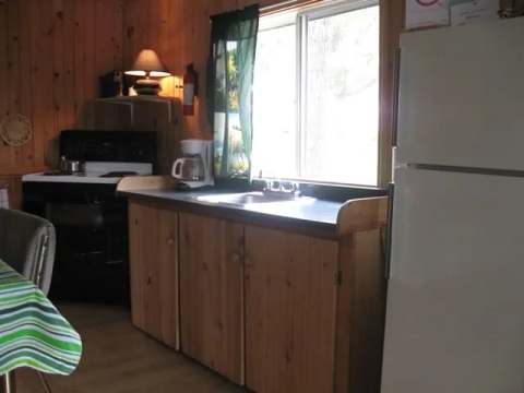 The equipped kitchen of cottage 3 includes a stove, a refrigerator, and a sink.