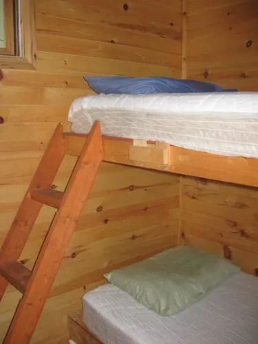 Chalet 2 is equipped with wooden bunk beds with mattresses.