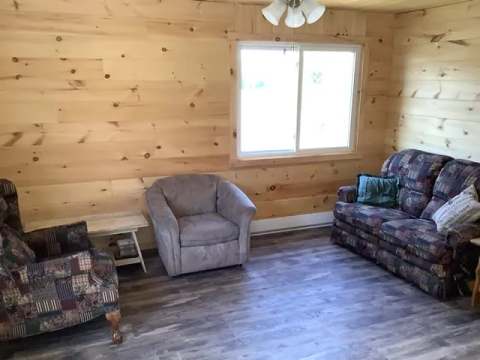 The cottage living room is furnished with a sofa and comfortable armchairs.
