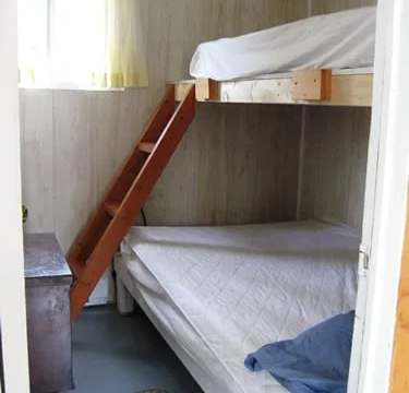 This bedroom features a bunk bed with a small dresser.