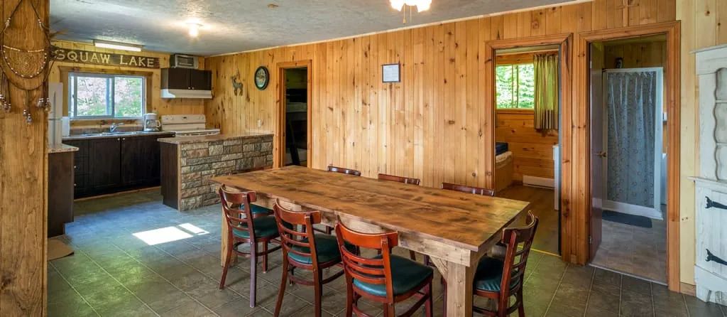 Overview of the living area featuring a functional kitchen and a wooden dining table.
