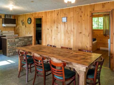 Overview of the living area featuring a functional kitchen and a wooden dining table.