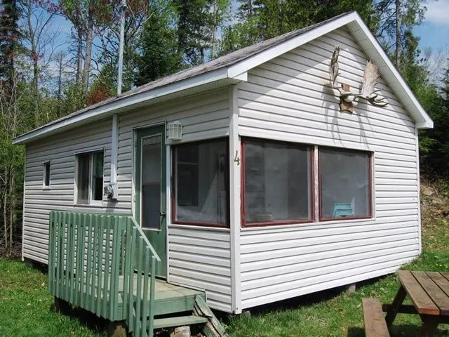 Exterior view of cabin number 4, featuring a screened porch and a picnic table.